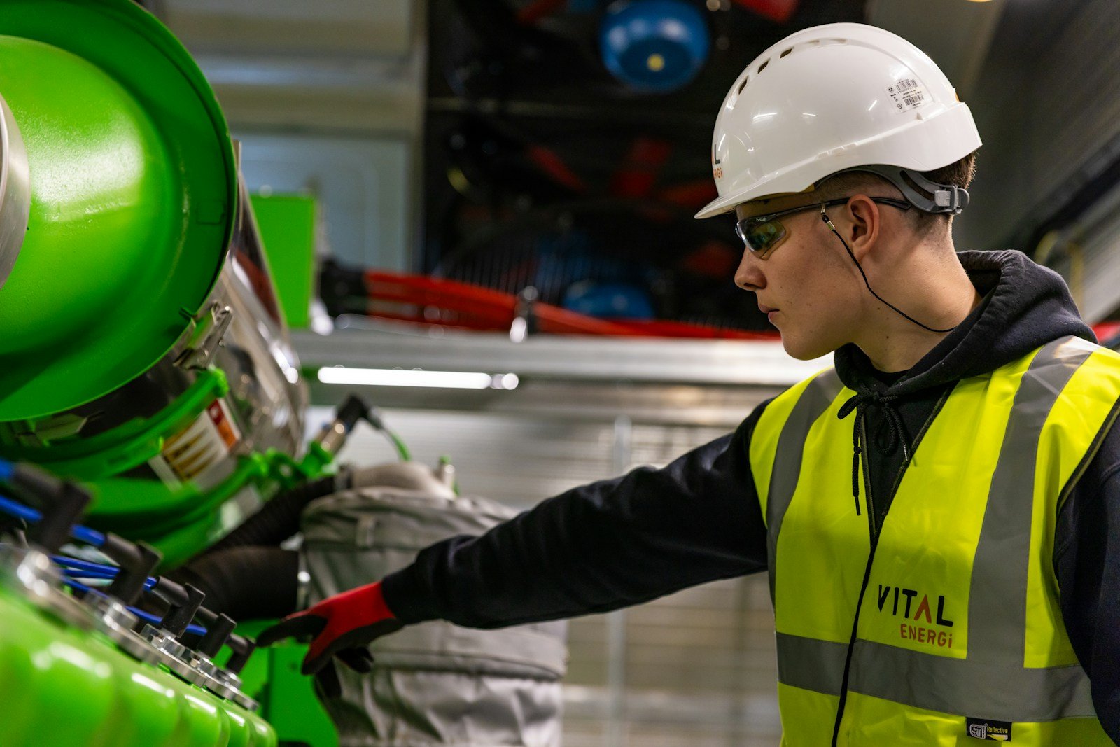Risitinerig inspector in hard hat and hi-vis examining rig equipment during an inspection